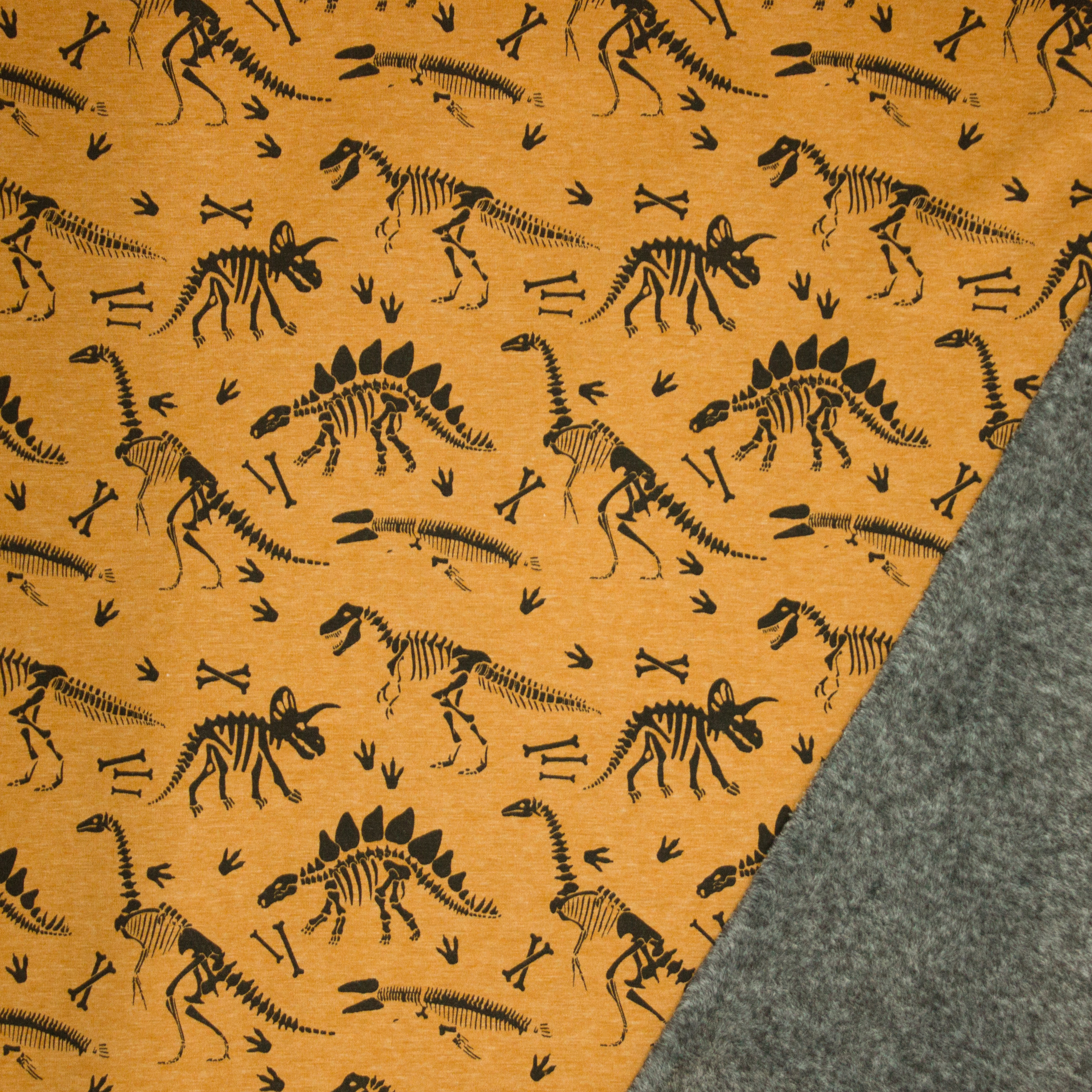 Oker gemêleerde sweaterstof met dino skeletten, achterkant grijs pelsje