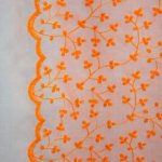 Broderie polyester met neon oranje motief en golvende rand - Burda