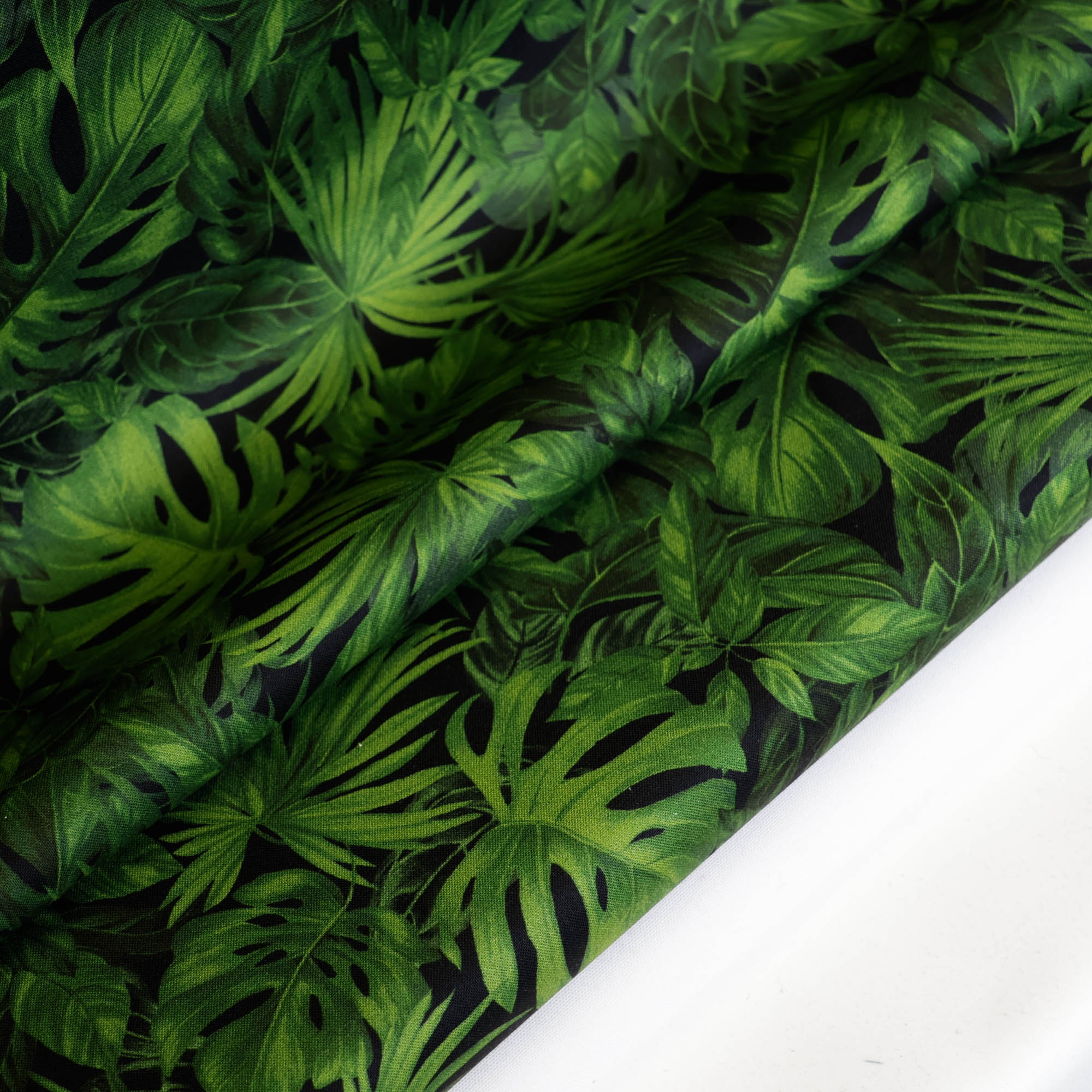 Katoen zwart met groene tropische bladeren