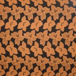 Zwarte viscose  tricot met oker bloemenmotief