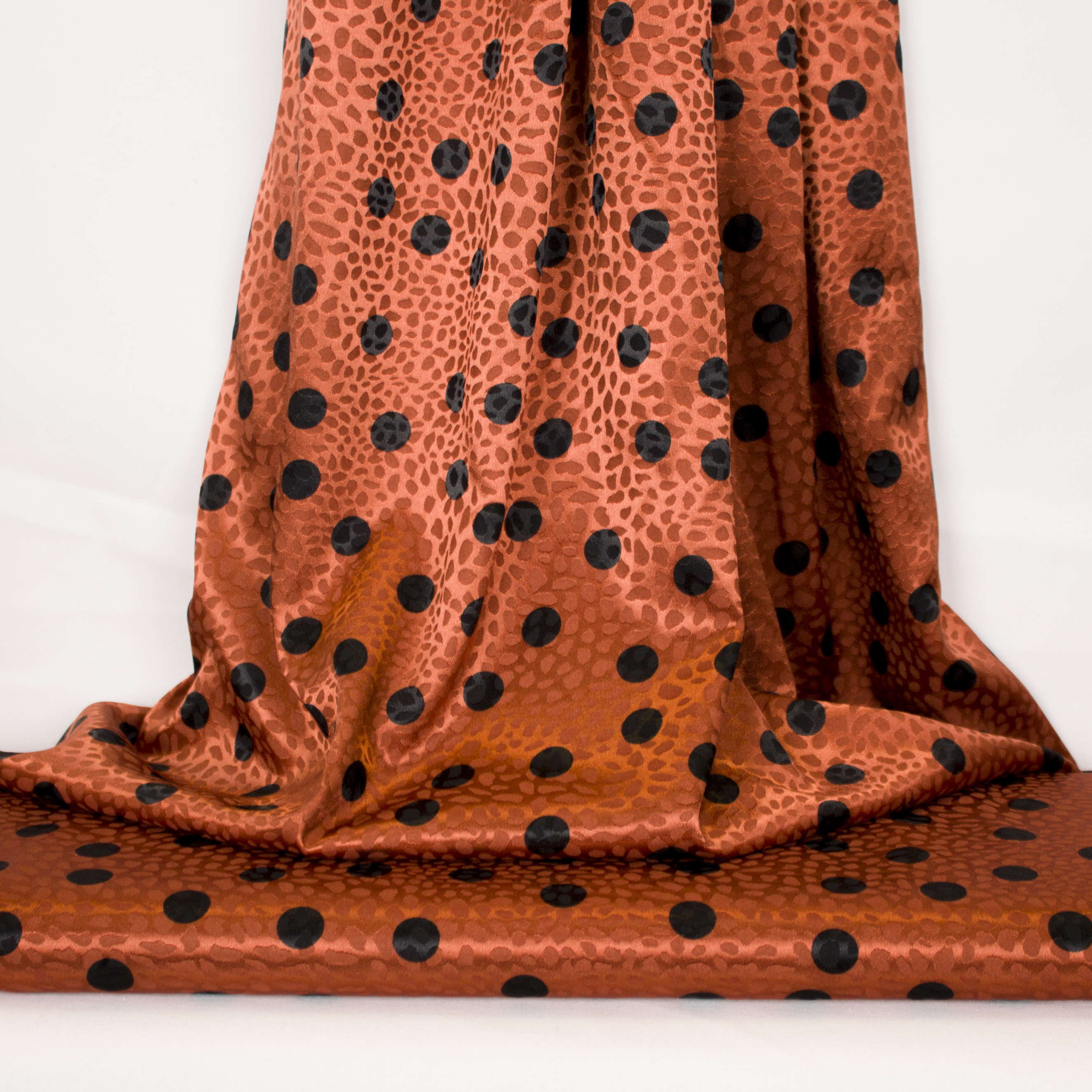 Gesatineerde polyester jacquard stretch oranje met zwarte stippen