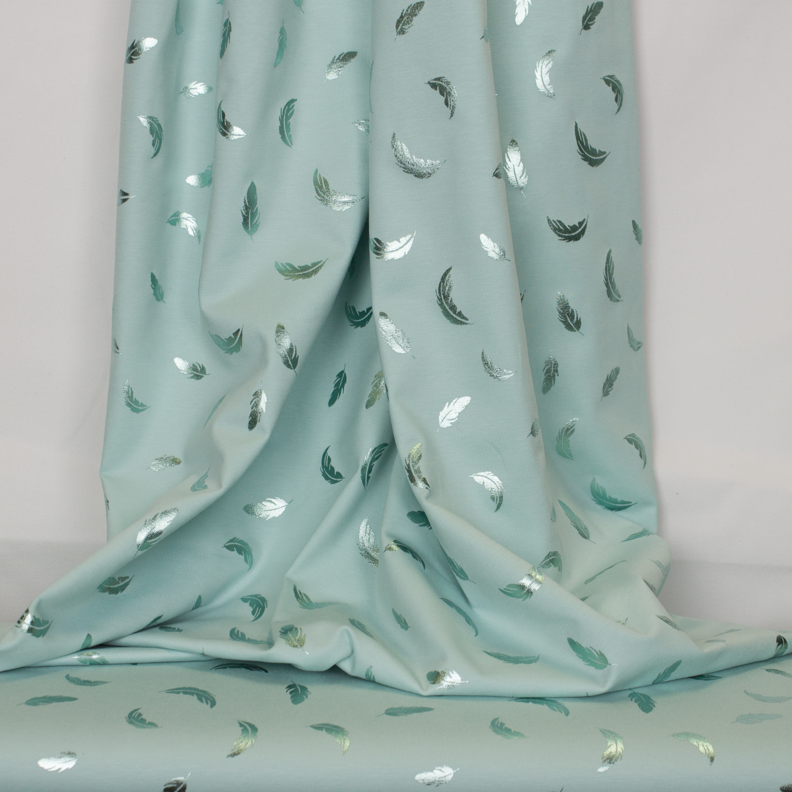 Turquoise tricot met weerspiegelende veertjes