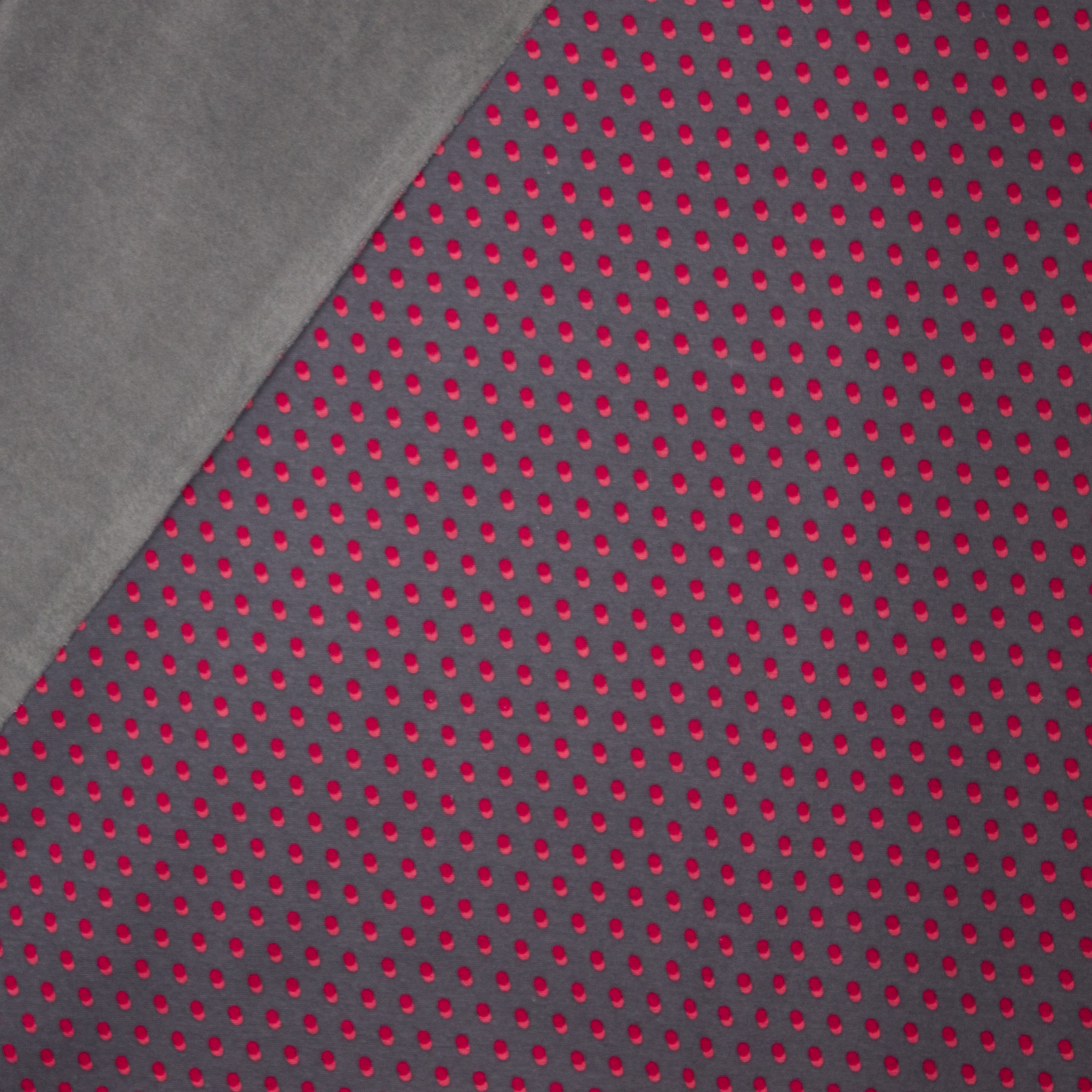 Donkergrijze sweaterstof met bolletjesmotief en zachte grijze achterkant