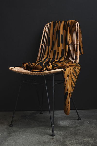 Oker kleurige viscose met motief van Mind The Maker.